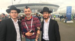 הרב פייקובסקי ושליחי חב"ד עם אוהד שהניח תפילין בכניסה לאצטדיון צילום: באדיבות המצלם חדשות