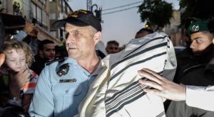קצין משטרה עם אחד מספרי התורה שנגנבו צילום: דוברות המשטרה ביטחון