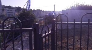 דגלי ישראל מכופפים ליד האנדרטה. צילום: ללא חדשות
