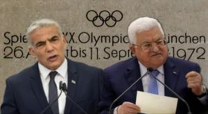 לפיד ואבו מאזן על רקע קיר זיכרון לטבח במינכן צילום: Shutterstock/Flash90 חדשות