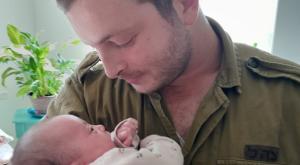 שי אוריאל פיזם עם ביתו בת השלושה שבועות צילום: דובר צה"ל חדשות