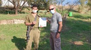 החייל עידו גרדי מקבל תעודת הוקרה על אזרחות טובה מניר דיסטלפלד, פקח רשות העתיקות צילום: רשות העתיקות חדשות