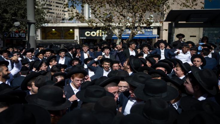 בקבוקים, מקלות ואבני חצץ: מפגינים חרדים תקפו את כתבת חדשות 12