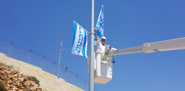 ראש מועצת בנימין, אבי רואה, עם דגל הריבונות