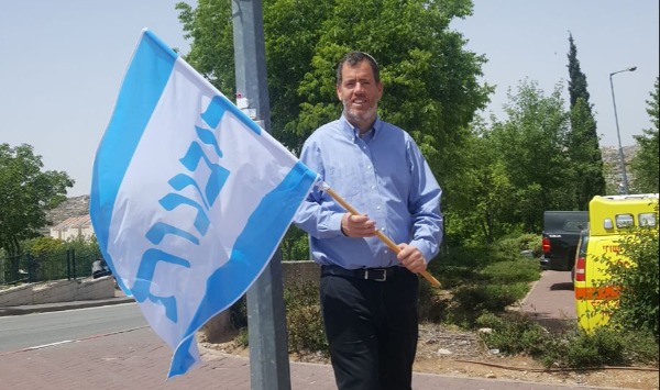 ראש מועצת קריית ארבע, מלאכי לוינגר, עם דגל הריבונות
