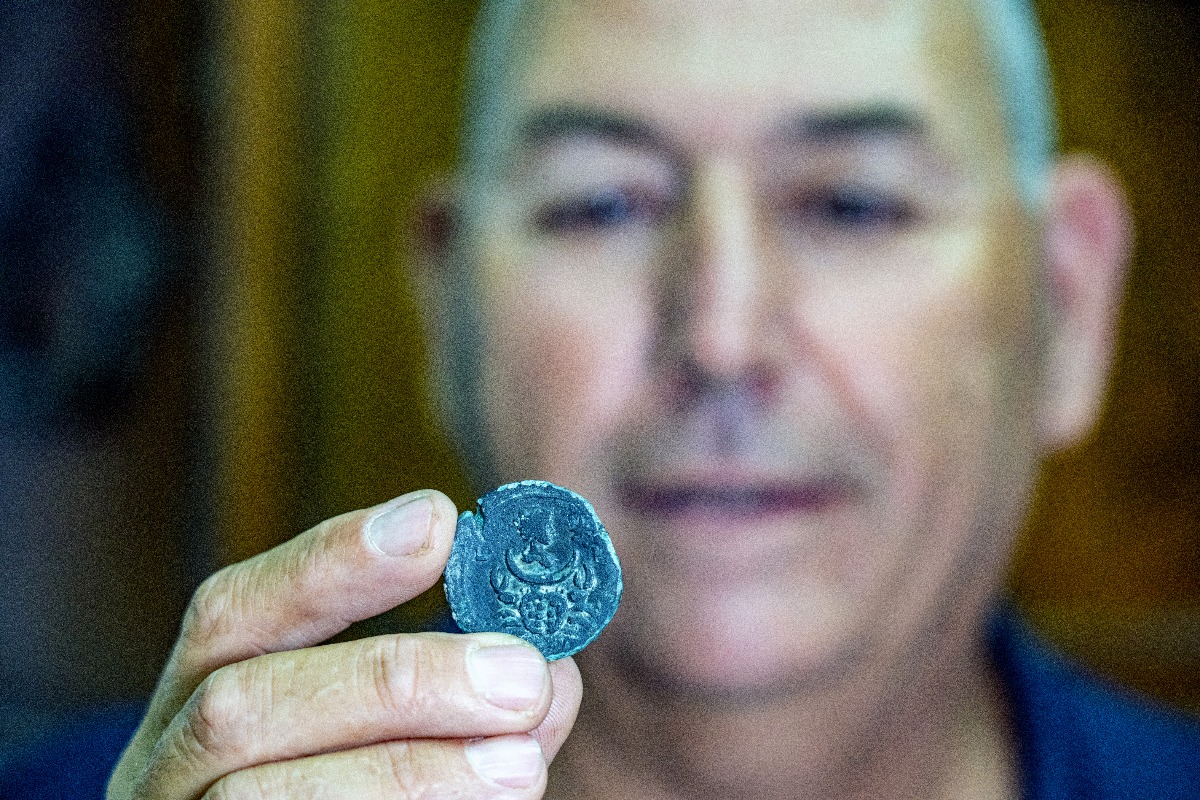 קובי שרביט, מנהל היחידה הימית של רשות העתיקות, עם המטבע שנמצא בסקר