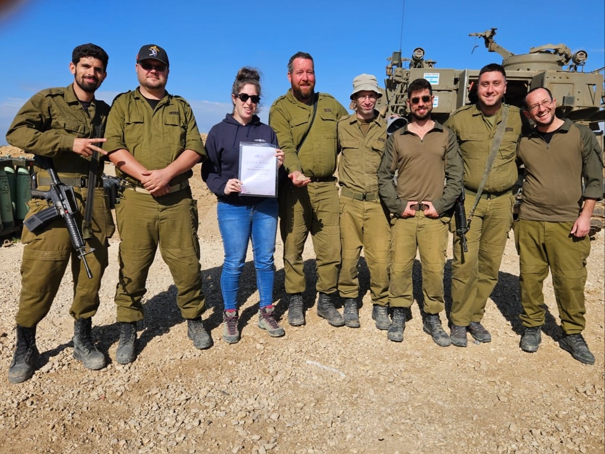 ארכיאולוגית רשות העתיקות שרה טל עם החיילים, הנר והתעודה שקיבלו
