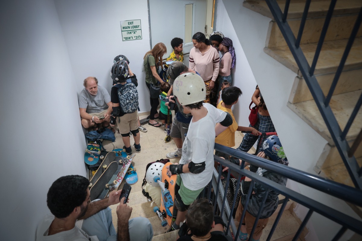 אזרחים מסתתרים בחדר מדרגות בתל אביב לאחר הפעלת אזעקות בעיר