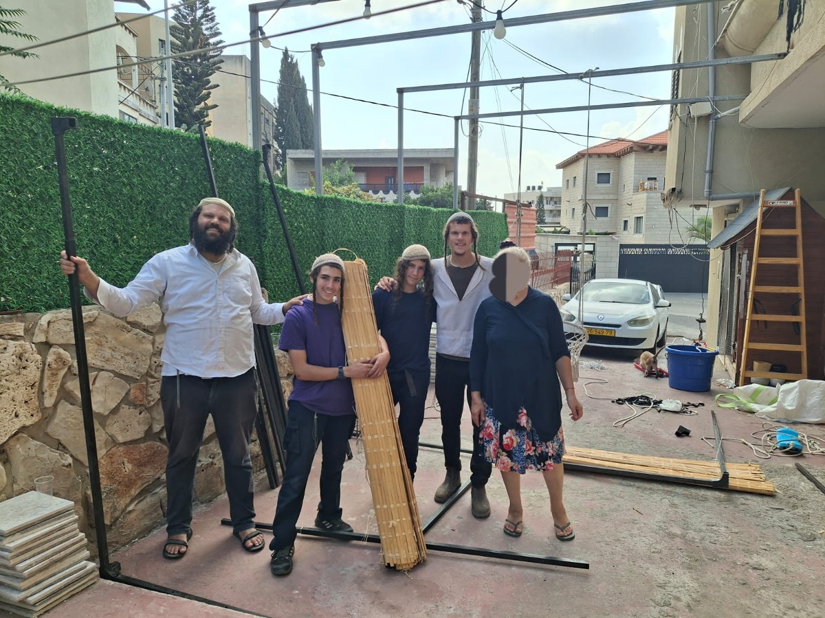 הרב אביעד עם בת שבע והנערים בבניית הסוכה
