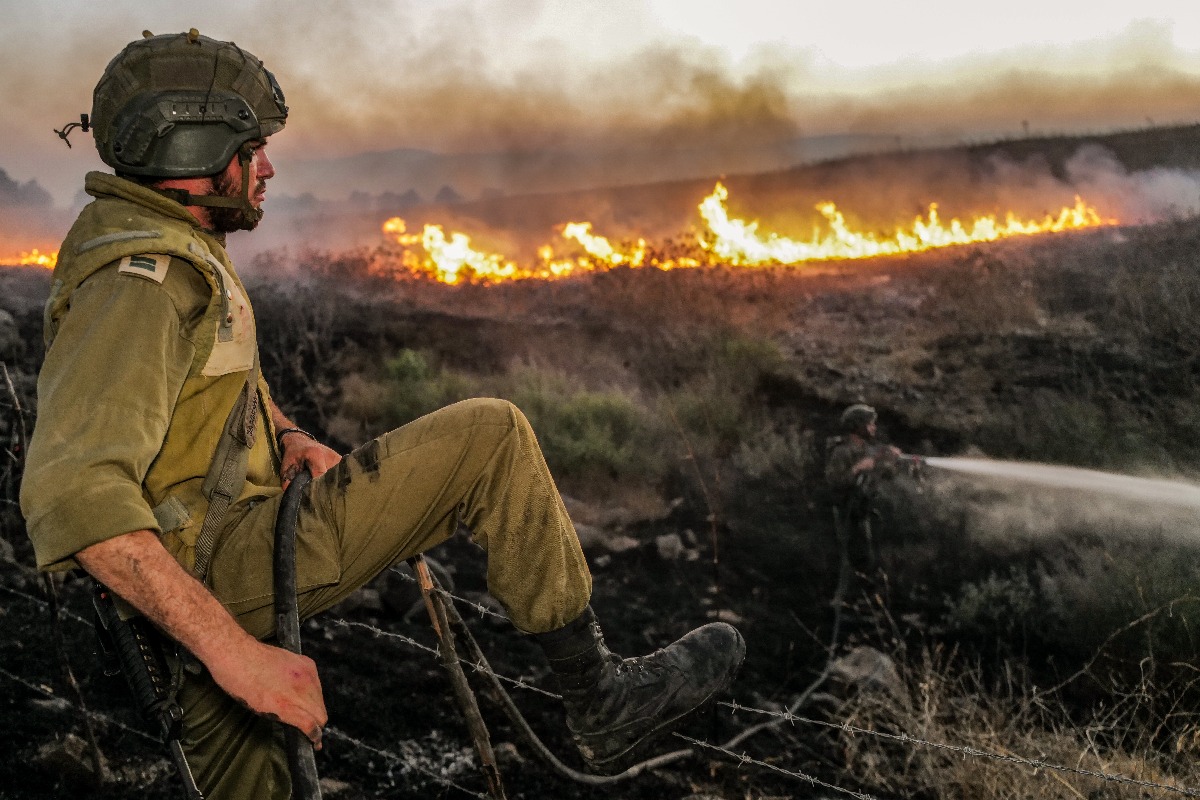 לוחם משקיף על שריפה שהתפתחה בסמוך לצומת נפח בעקבות פגיעת רקטה