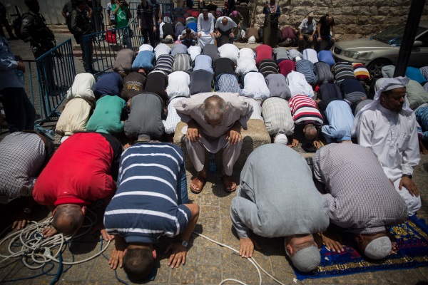 מוסלמים מתפללים בשער האריות כדי לא לעבור את הבידוק בהר הבית